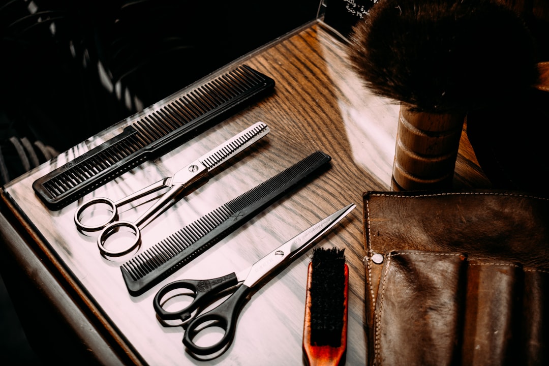 Kadeřnické nástroje na dřevěném stole — zátiší z barbershopu